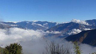 Wolken &uuml;ber dem Tal - schneebedeckte Himalaya-Eisriesen &uuml;ber den Bergk&auml;mmen. - Ost-Bhutan: Landschaft